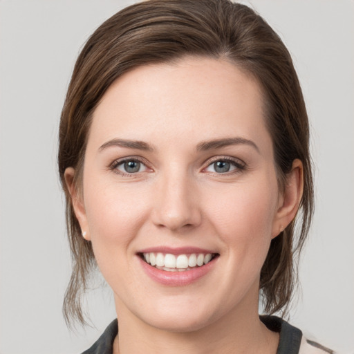 Joyful white young-adult female with medium  brown hair and grey eyes