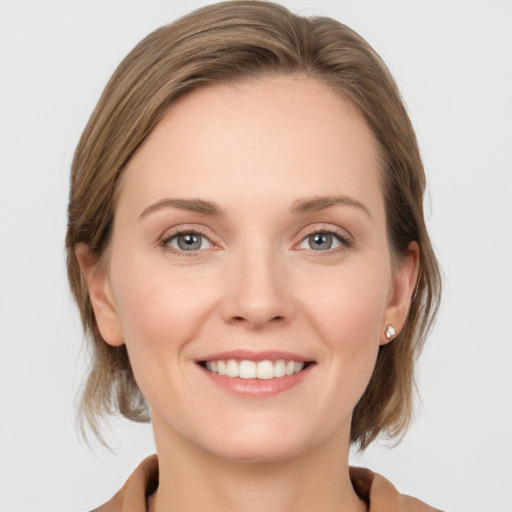 Joyful white young-adult female with medium  brown hair and grey eyes