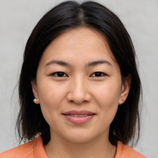 Joyful asian young-adult female with medium  brown hair and brown eyes