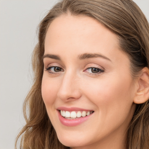 Joyful white young-adult female with long  brown hair and green eyes