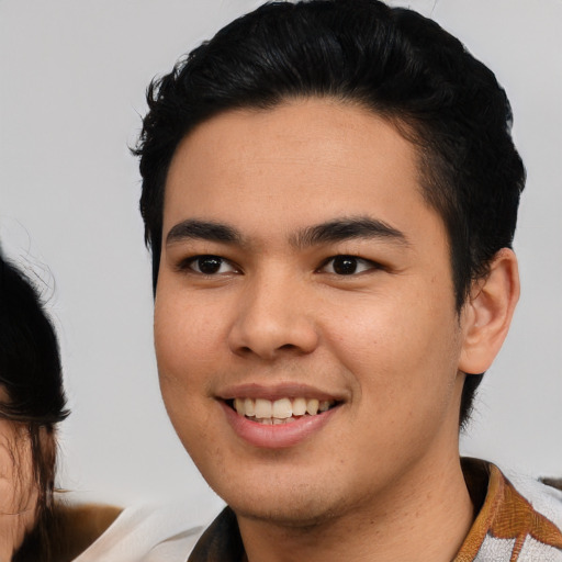 Joyful white young-adult male with medium  black hair and brown eyes