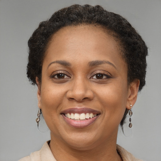 Joyful black adult female with short  brown hair and brown eyes