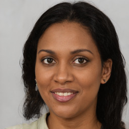 Joyful black young-adult female with medium  brown hair and brown eyes