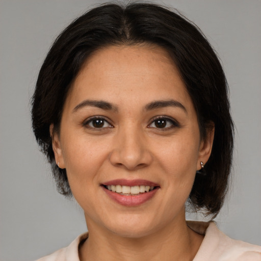 Joyful latino adult female with medium  brown hair and brown eyes