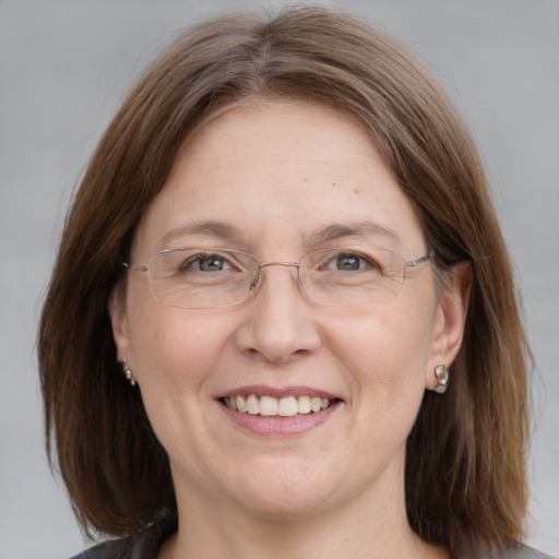 Joyful white adult female with medium  brown hair and grey eyes