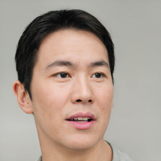 Joyful asian adult male with short  black hair and brown eyes