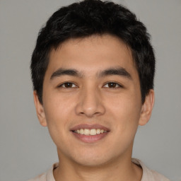 Joyful asian young-adult male with short  black hair and brown eyes