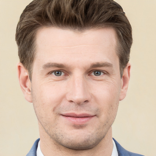 Joyful white young-adult male with short  brown hair and grey eyes