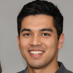 Joyful white young-adult male with short  black hair and brown eyes