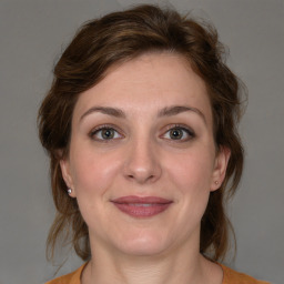 Joyful white young-adult female with medium  brown hair and blue eyes