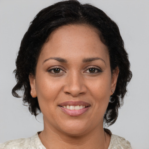 Joyful latino adult female with medium  brown hair and brown eyes