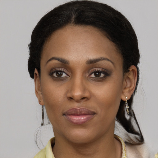 Joyful black young-adult female with medium  brown hair and brown eyes