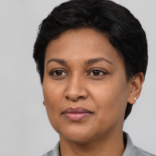 Joyful black adult female with short  black hair and brown eyes