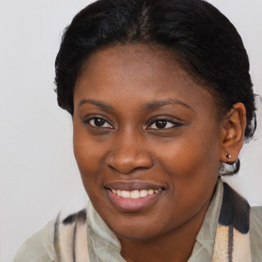 Joyful black young-adult female with short  brown hair and brown eyes