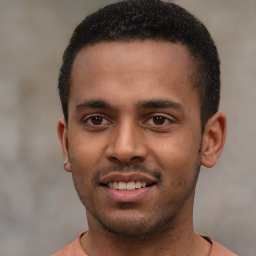 Joyful black young-adult male with short  brown hair and brown eyes