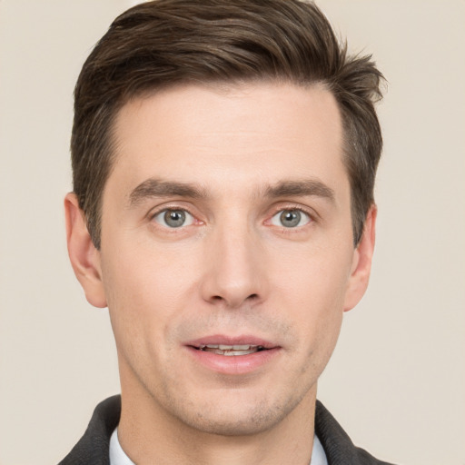 Joyful white young-adult male with short  brown hair and grey eyes