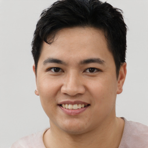 Joyful asian young-adult male with short  black hair and brown eyes