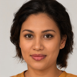 Joyful latino young-adult female with medium  brown hair and brown eyes