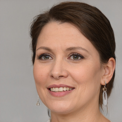 Joyful white adult female with medium  brown hair and grey eyes