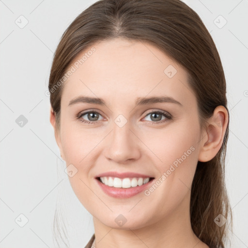 Joyful white young-adult female with medium  brown hair and grey eyes