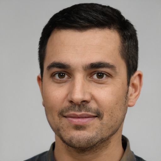 Joyful white young-adult male with short  black hair and brown eyes