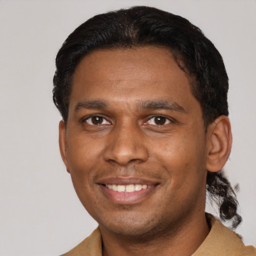 Joyful black young-adult male with short  black hair and brown eyes