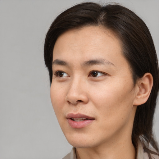 Joyful asian adult female with medium  brown hair and brown eyes