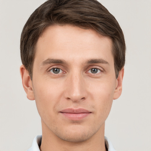 Joyful white young-adult male with short  brown hair and grey eyes