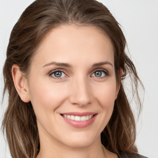 Joyful white young-adult female with medium  brown hair and grey eyes