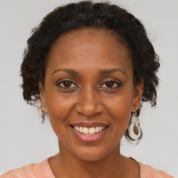 Joyful black adult female with medium  brown hair and brown eyes