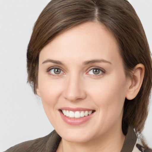 Joyful white young-adult female with medium  brown hair and grey eyes