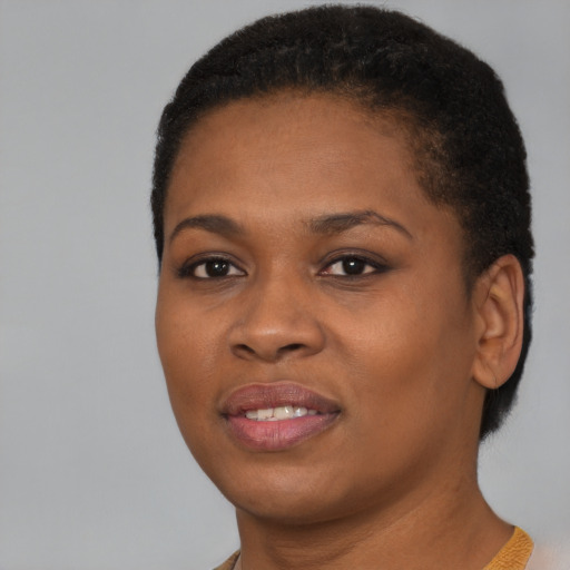 Joyful black young-adult female with short  black hair and brown eyes