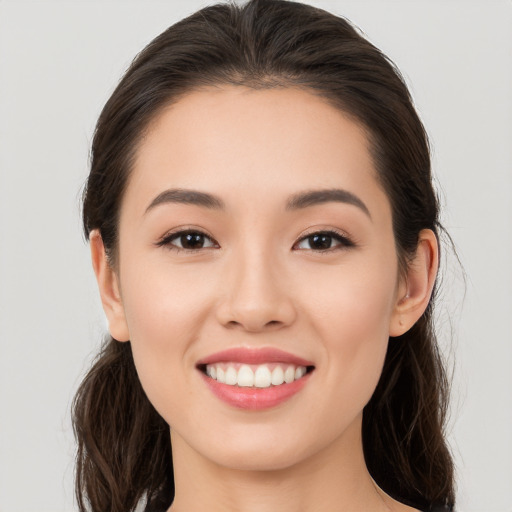 Joyful white young-adult female with long  brown hair and brown eyes