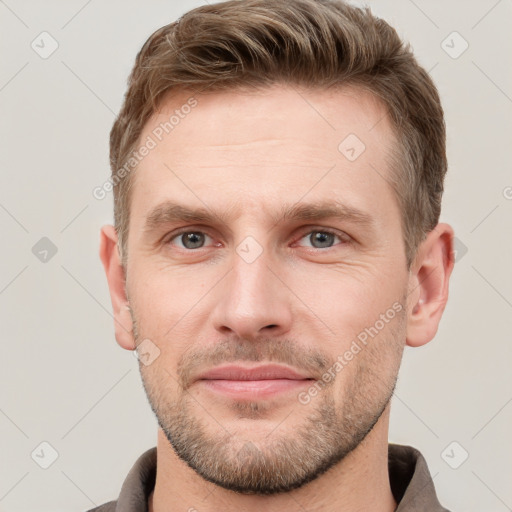 Joyful white young-adult male with short  brown hair and grey eyes