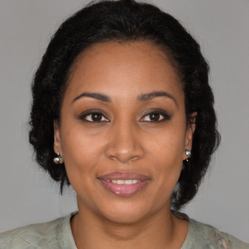 Joyful black young-adult female with medium  brown hair and brown eyes