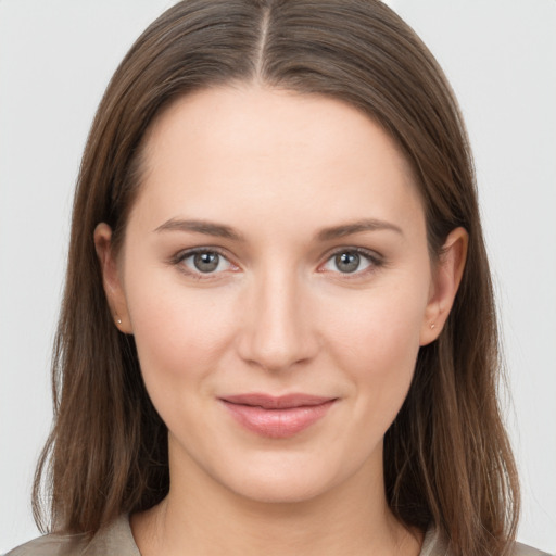 Joyful white young-adult female with long  brown hair and grey eyes