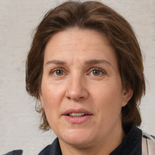 Joyful white adult female with medium  brown hair and grey eyes