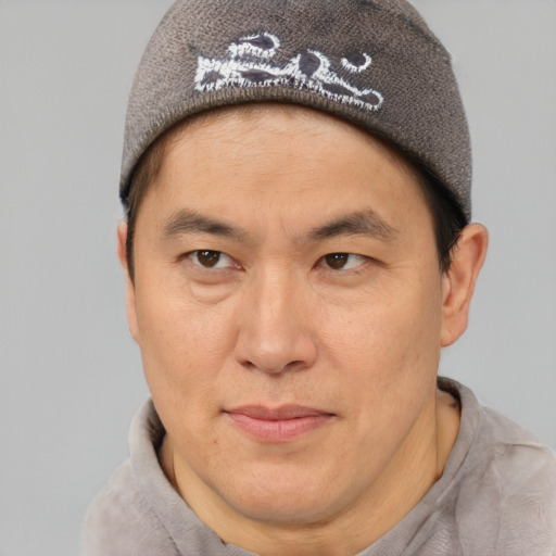 Joyful asian adult male with short  brown hair and brown eyes
