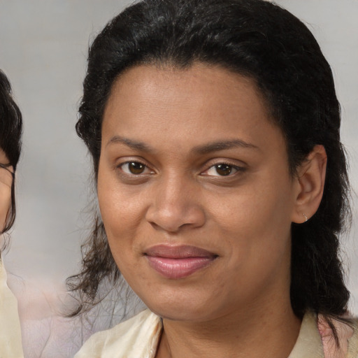Joyful black adult female with medium  brown hair and brown eyes