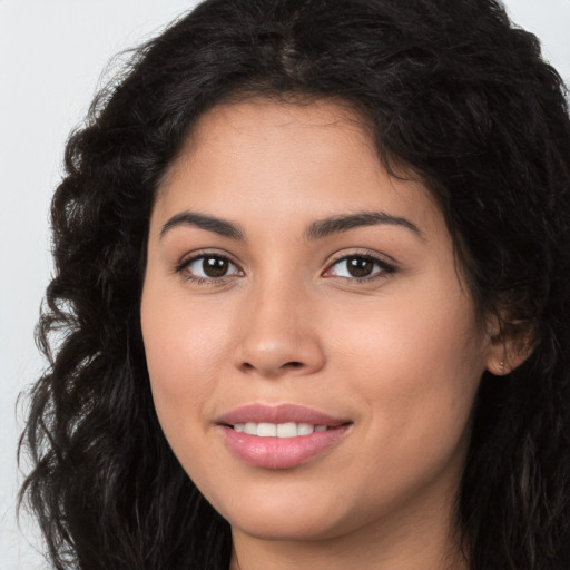 Joyful latino young-adult female with long  brown hair and brown eyes