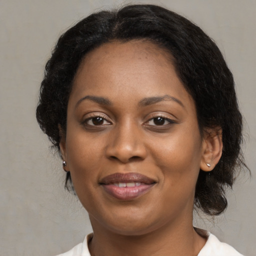 Joyful black adult female with medium  brown hair and brown eyes