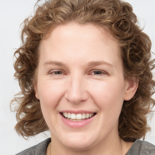 Joyful white young-adult female with medium  brown hair and blue eyes