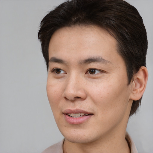 Joyful asian young-adult male with short  brown hair and brown eyes