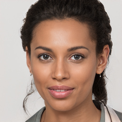 Joyful latino young-adult female with long  brown hair and brown eyes