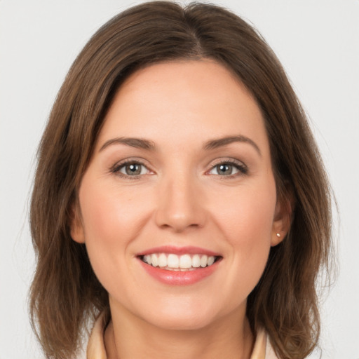 Joyful white young-adult female with medium  brown hair and green eyes