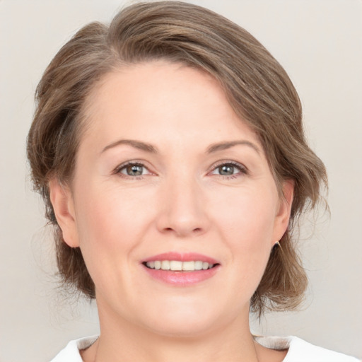 Joyful white adult female with medium  brown hair and grey eyes