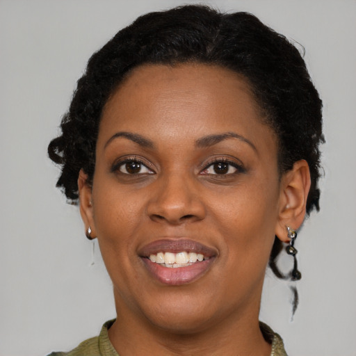 Joyful black young-adult female with short  brown hair and brown eyes