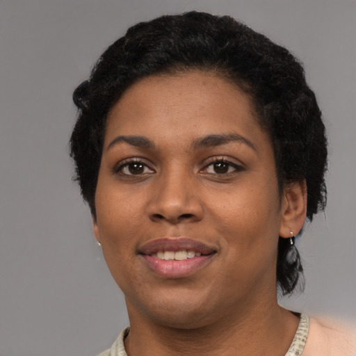 Joyful black young-adult female with short  black hair and brown eyes