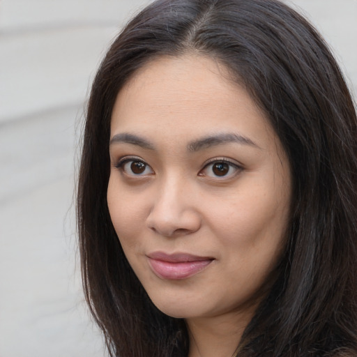 Joyful asian young-adult female with long  brown hair and brown eyes