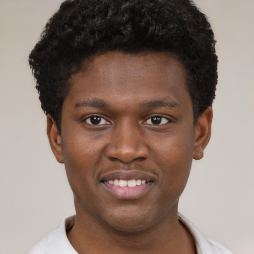 Joyful black young-adult male with short  brown hair and brown eyes